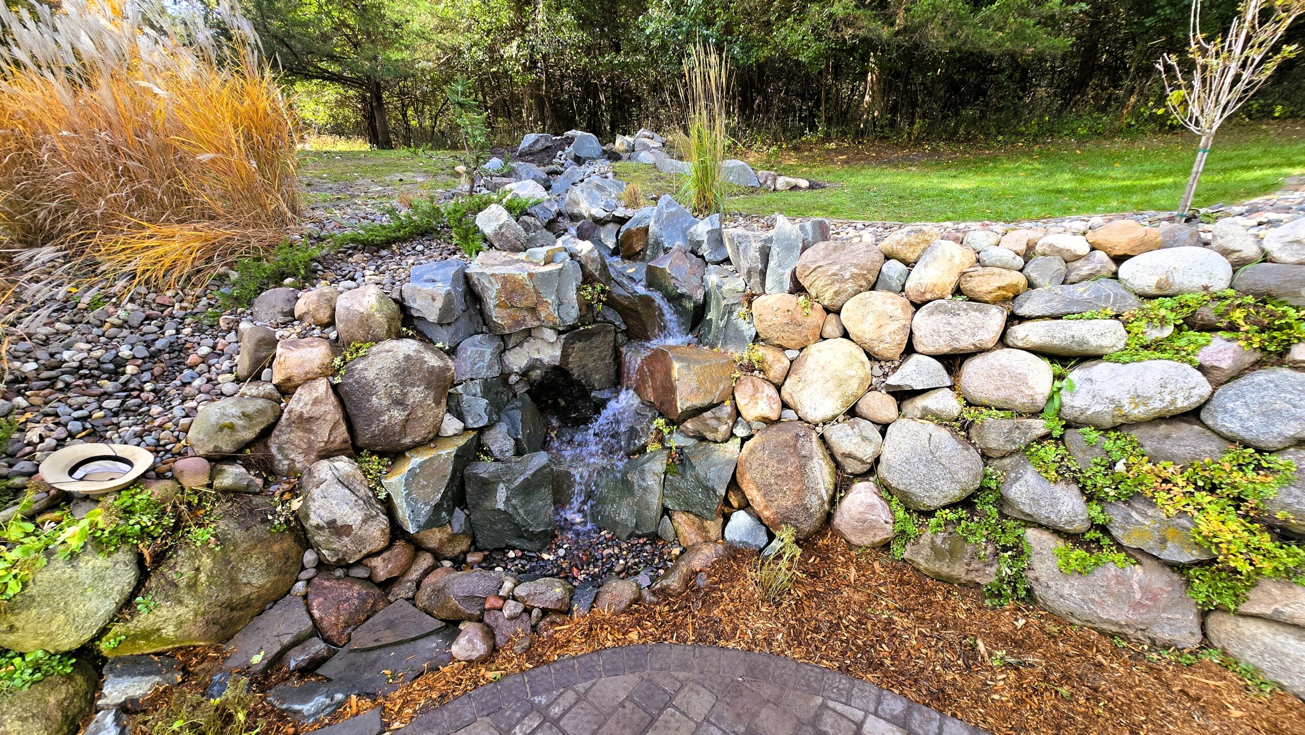 Large pondless waterfall and stream constructed with natural boulders in Ramsey, Minnesota