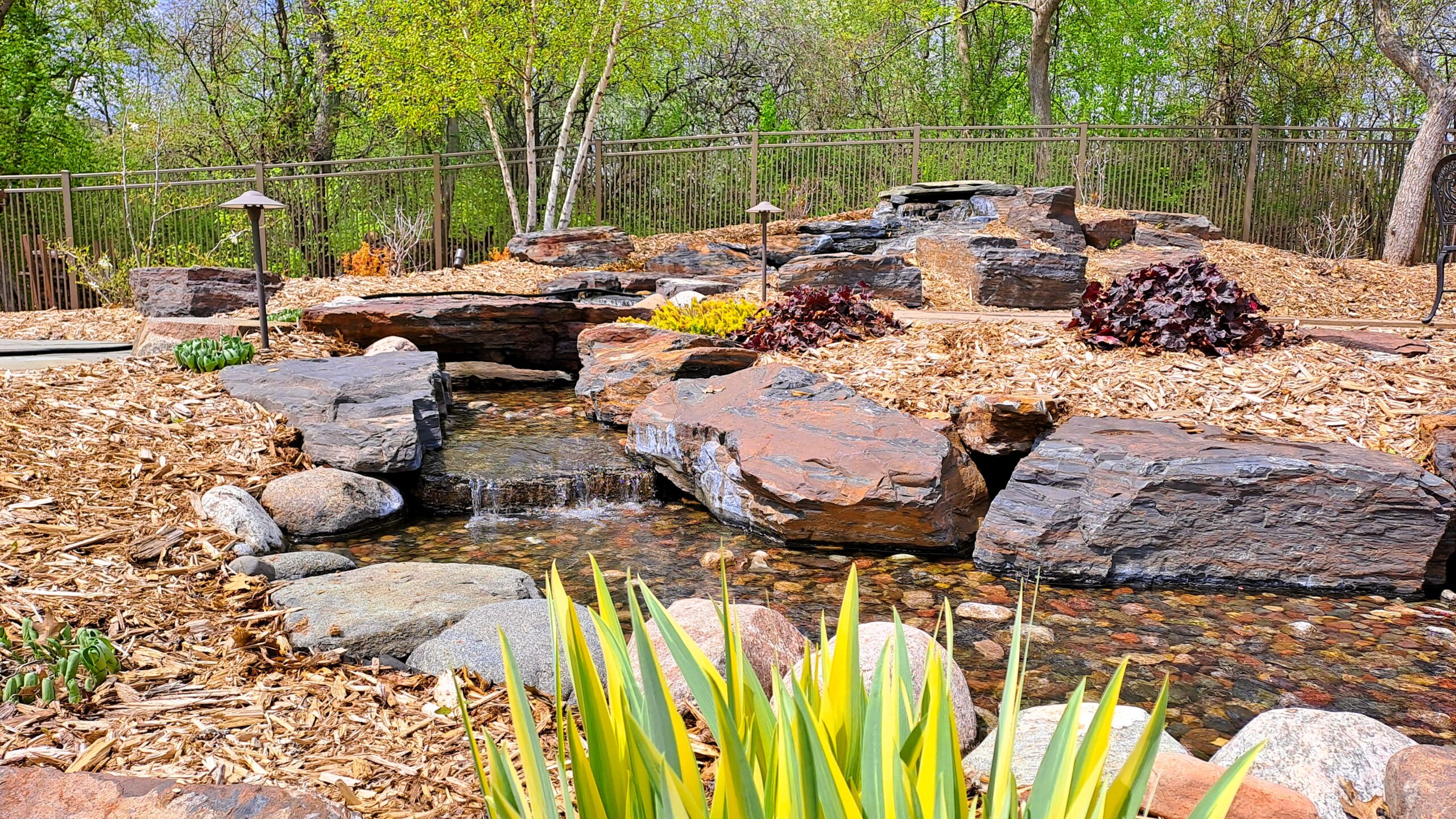 25-foot pondless waterfall in Rosemount, Minnesota built with Tiger stone, featuring natural rock cascades, a clear stream, premium boulders, and professional landscape design.