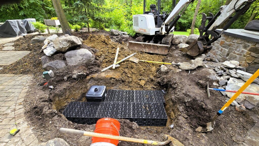 Installation of the Aquascape AquaBlox Water Storage Module forming the underground reservoir for a pondless waterfall system.