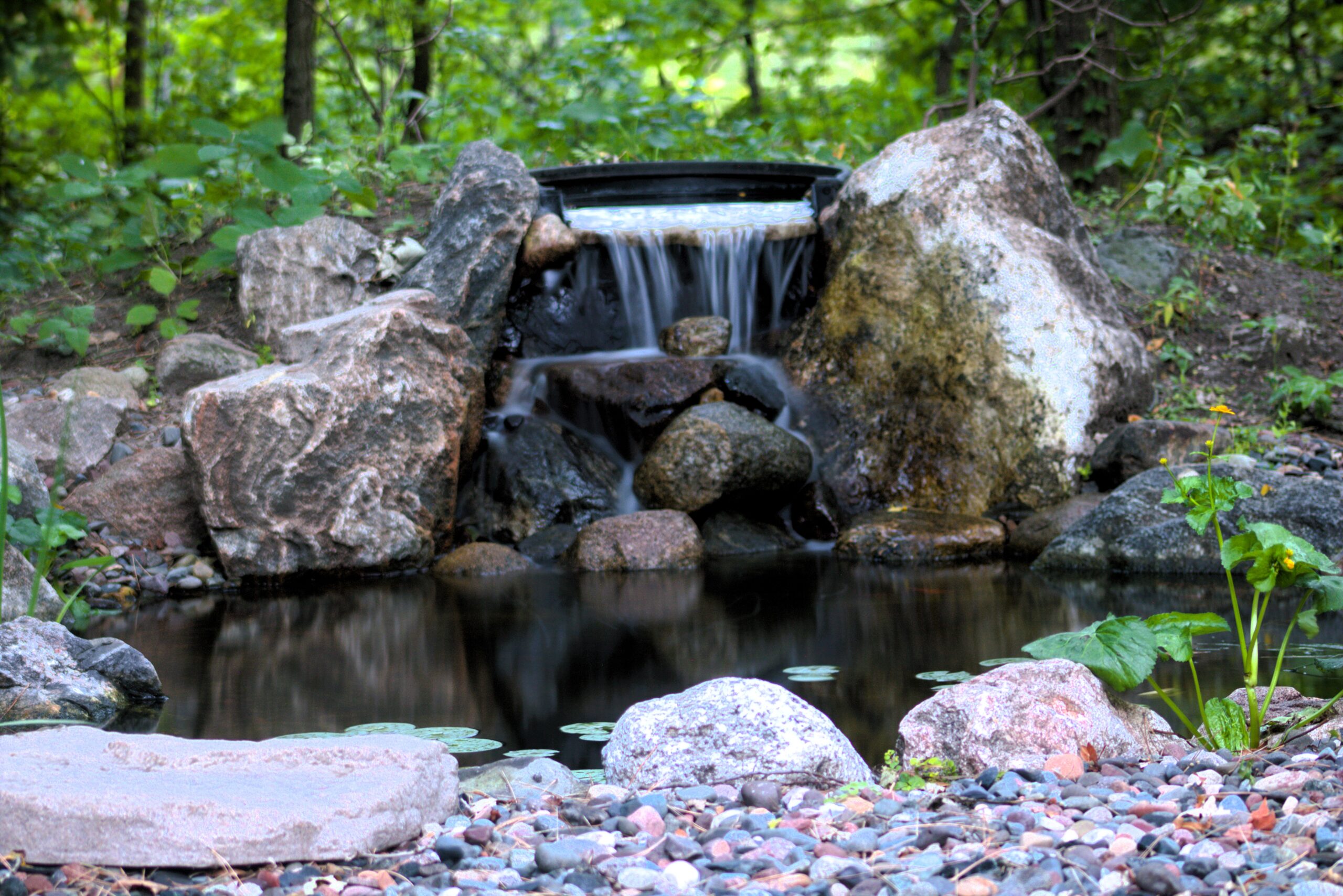 Woodland pond with natural stone waterfall and Aquascape BioFalls system in Chaska, Minnesota