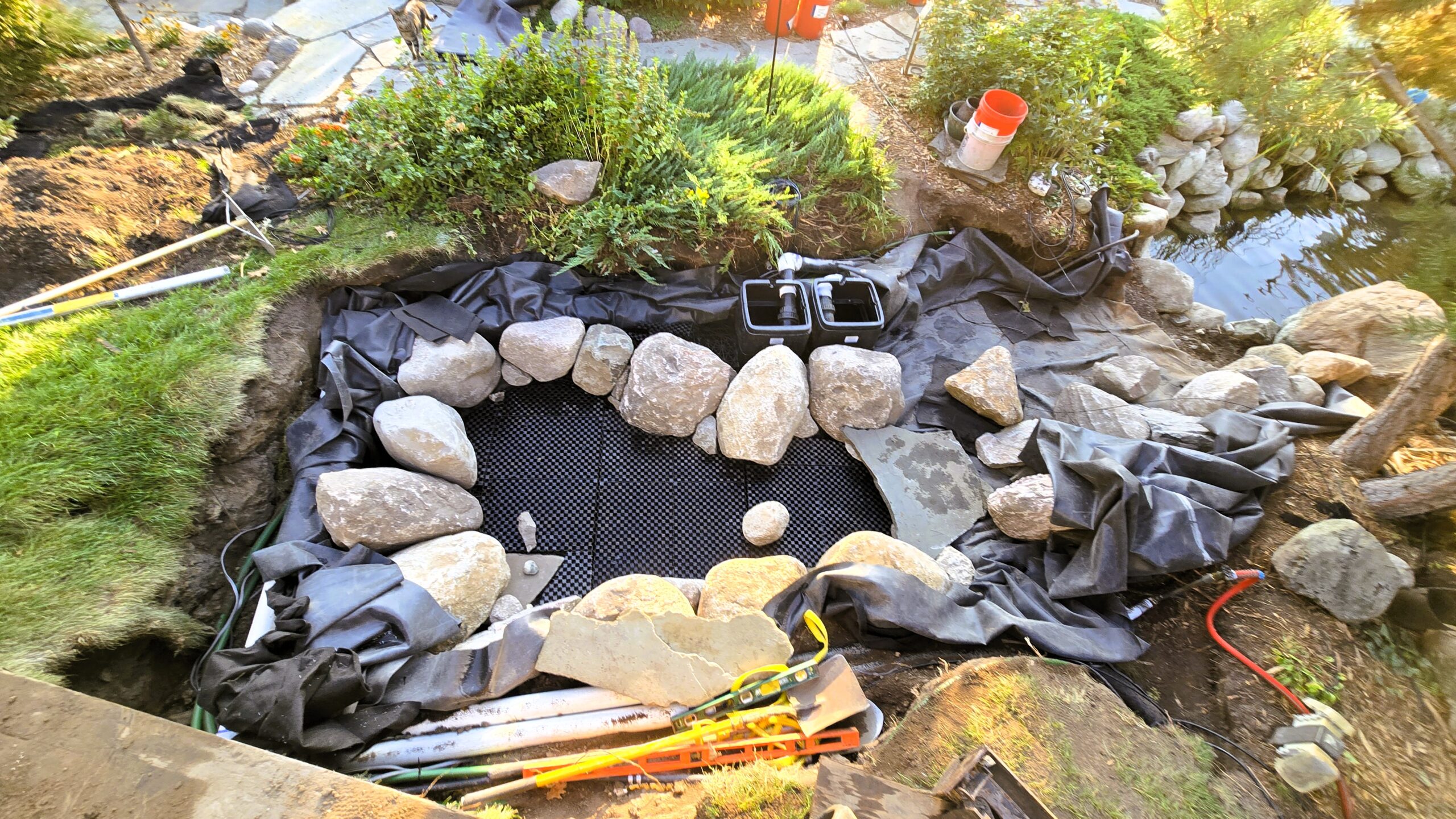 Intake bay construction with AquaBlox, liner installation, and stone placement for large swimming pond filtration system in Orono, Minnesota
