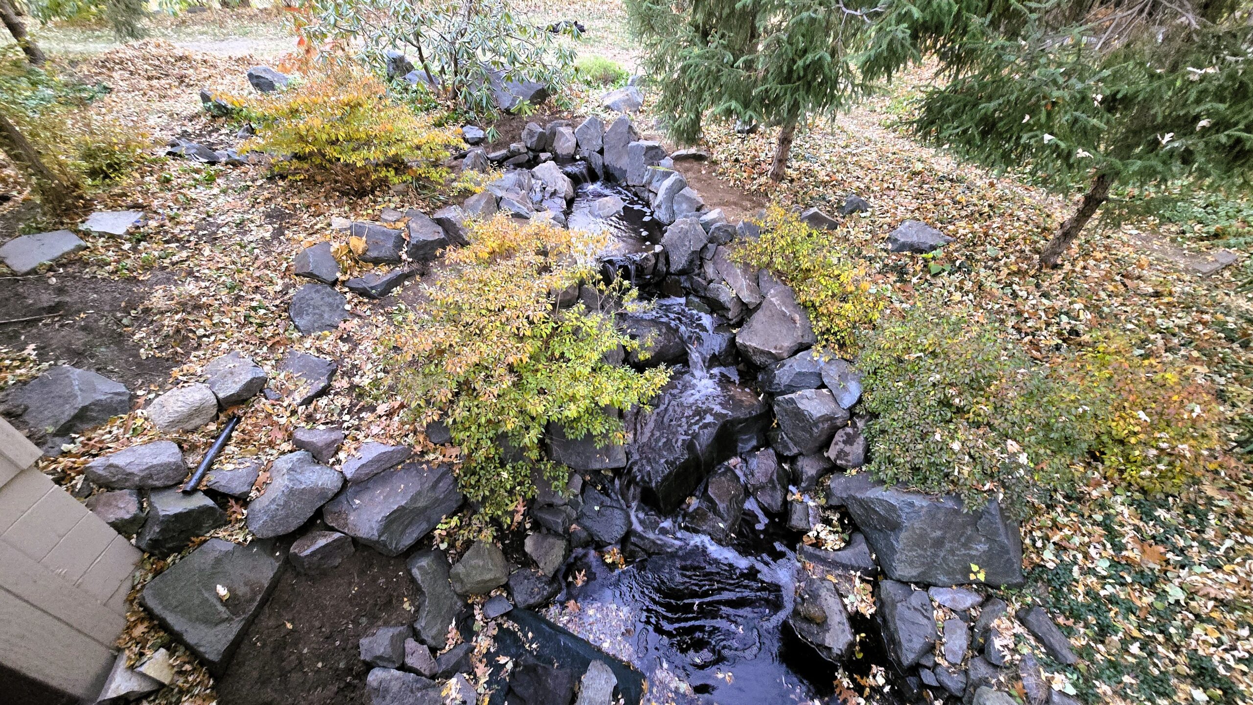 Overhead view of a reconstructed natural stone stream and waterfall using existing trap rock in Arden Hills, MN.