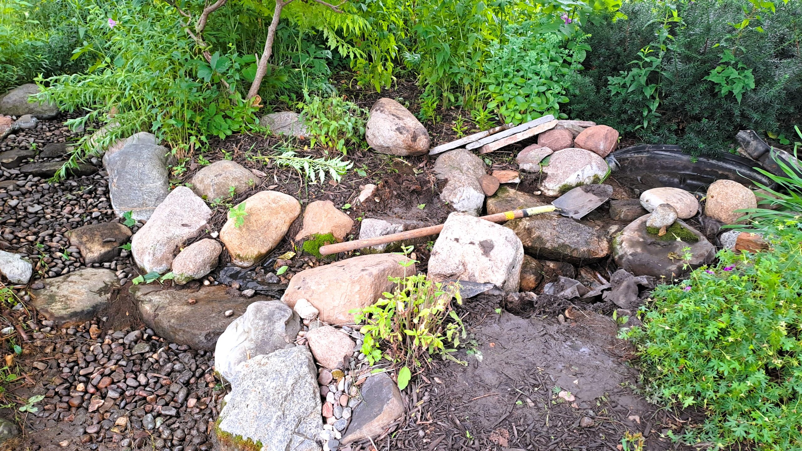 Backyard stream repair in progress in Rogers, MN, with rocks removed during a 6-foot stream rebuild.